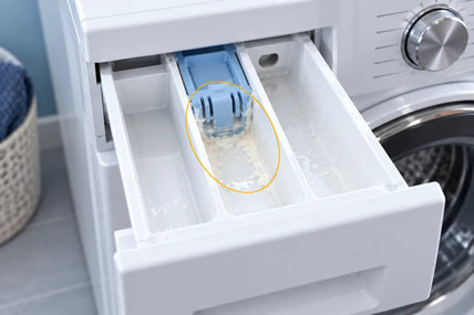 A pulled-out dispenser drawer with softener residue caked in the middle compartment, circled