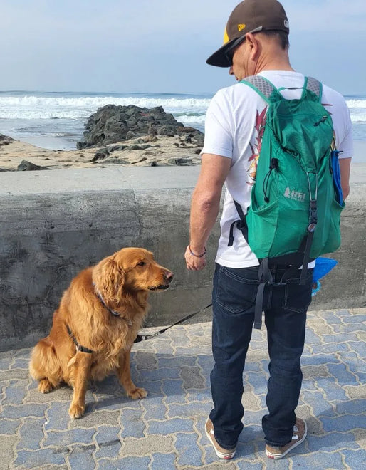 A team member and his golden retriever on the boardwalk by the beach